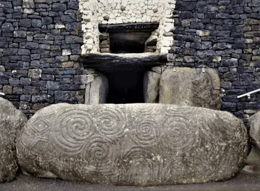 Espirales dobles tallados en una gran piedra ancha tumbada frente al umbral del monumento neolítico de Newgrange en Irlanda.